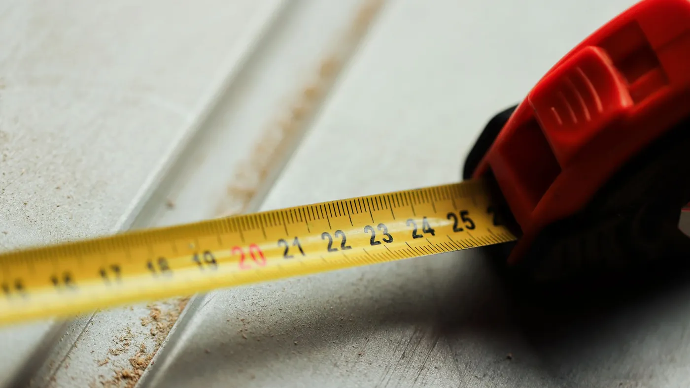 Close view of a tape measure extended across a construction surface