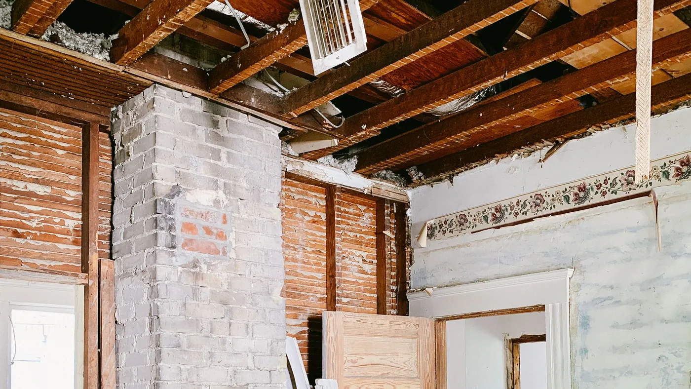 House mid-renovation with ceiling joists and brickwork exposed