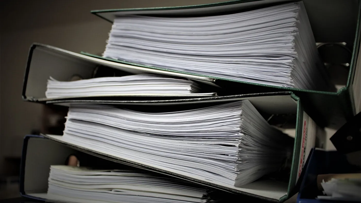 Stack of ring binders full of printed documents