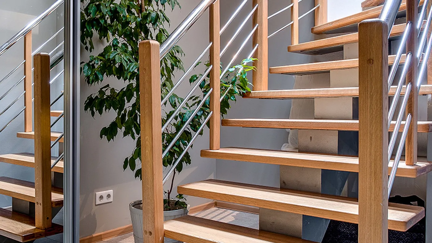 Open timber staircase with a steel balustrade in a bright hallway