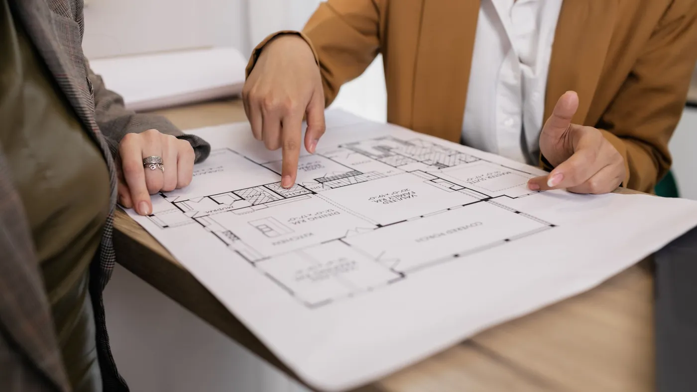 Two people going through a floor plan together at a table
