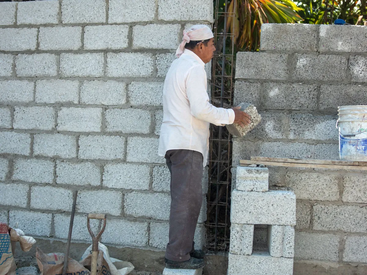 Builder laying blockwork for a new wall